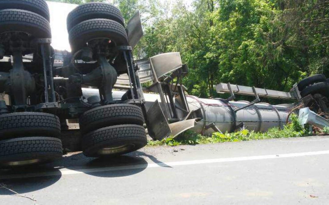 Rolled over DOT412 cargo tank truck with a corrosive material.